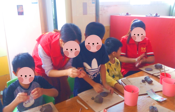 海口村文化保育志愿服务队成员与小朋友分享陶瓷制作工艺.jpg